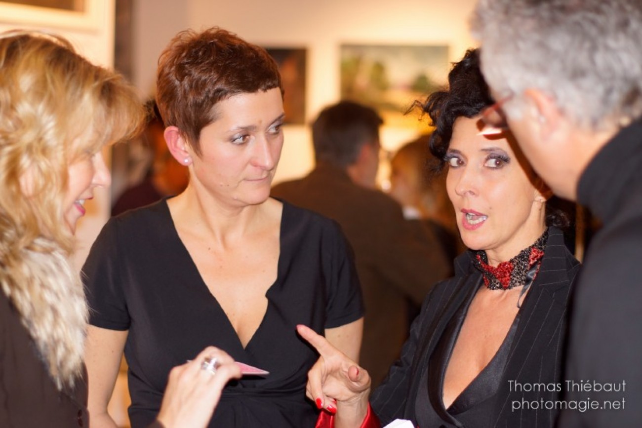 Magicienne au milieu des tableaux et des sculptures de l'exposition : belle soirée